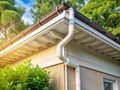 Pristine White Gutter and Downspout System on Modern Beige Home Efficient Rainwater Management and Drainage Royalty Free Stock Photo