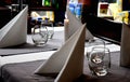 Pristine, white restaurant table with glasses of water and folded napkins