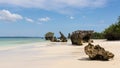 Pristine white tropical beach with rocks, blue sea and lush vegetation on the African Island of Misali, Pemba, Zanzibar.