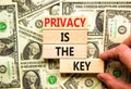 Privacy is the key symbol. Concept words Privacy is the key on wooden blocks on a beautiful background from dollar bills. Royalty Free Stock Photo