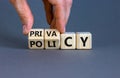 Privacy policy symbol. Hand turns the wooden cube with words `Privacy policy` on a beautiful grey background. Business and priva