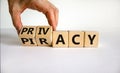 Privacy vs piracy symbol. Businessman hand turns cubes and changes the word `piracy` to `privacy`. Beautiful white background,