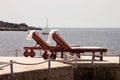 Private beaches on mediterranean sea. Chairs, deck chairs, sun loungers and parasols waiting for tourists.