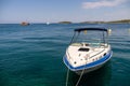 Private boat with rope by the harbor with the background of a tropical island