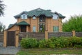 Private brown brick house with windows behind a wooden fence in the grass Royalty Free Stock Photo