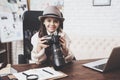 Private detective agency. Little girl is sitting at desk looking at photos in camera. Royalty Free Stock Photo