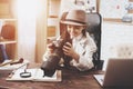 Private detective agency. Little girl is sitting at desk looking at photos in camera. Royalty Free Stock Photo