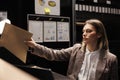 Private detective putting files on shelf