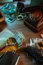 Private detective`s desk, noir still life with a vintage phone, typewriter, lamp, gun and retro photos Royalty Free Stock Photo