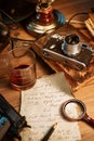 Private detective`s desk, noir still life with a vintage phone, typewriter, lamp, gun and retro photos Royalty Free Stock Photo