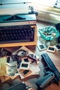 Private detective`s desk, noir still life with a vintage phone, typewriter, lamp, gun and retro photos Royalty Free Stock Photo