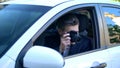 Private detective spying from car, taking photos on camera, investigation Royalty Free Stock Photo