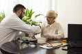 A private doctor`s office. Geriatrician doctor takes the patient and measure her blood pressure.