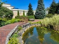 A private estate with a pond, a bridge and a bench. Decorative fish swim in the reservoir