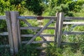 Private farm land fenced off by a large gate with a private keep out sign showing no access to the rural pathway