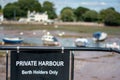 Private harbour berth holders only sign in black at a pretty harbor. Royalty Free Stock Photo