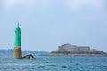 Private house and green lighthouse in the bay of Saint-Malo