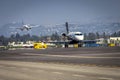 Private jet taxiing with Commercial jet diffused landing in distance