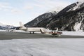 Private jets and a propeller type airplane taking off in the airport of St Moritz Switzerland in winter Royalty Free Stock Photo