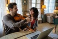 Private male music teacher giving violin lessons to a woman at home Royalty Free Stock Photo