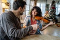 Private male music teacher giving violin lessons to a woman at home Royalty Free Stock Photo