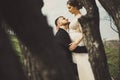 Private photo peeping from behind the bride and groom from the trees. Amorous couple on a natural background. In artistic creative Royalty Free Stock Photo