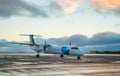 Private propeller-driven airplane parking at the airport with sunset background. Royalty Free Stock Photo