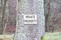 Private property sign fixed to tree in woodlands