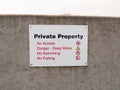 Private property sign on grey sea wall barricade no permission Royalty Free Stock Photo