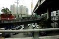 Private and public vehicles pass an overpass or bridge over a traffic congested major road