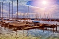 Private small sailing boats and yachts lay unpacked on the pier of the lake in the sun Royalty Free Stock Photo