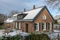 Private solar panels with snow on the roof of old historic and monumental house Royalty Free Stock Photo