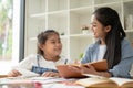 A private teacher and a young girl are laughing and enjoying the English class together Royalty Free Stock Photo