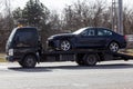 Private towing vehicle for emergency vehicle movement. Passenger car after an accident on a forklift truck on the road in motion