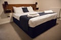 Double bed with bedding in clean simple basic hotel room Royalty Free Stock Photo