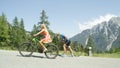 Pro biker gives up and walks along his road bicycle as blonde girl overtakes him Royalty Free Stock Photo