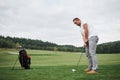 Pro golf player aiming shot with club on course. Male golfer on putting green about to take the hit Royalty Free Stock Photo