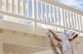 Pro House Painter Spray Painting A Deck of A Home Royalty Free Stock Photo