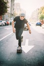 Pro skateboard rider in front of car on city street