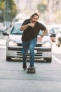 Pro skateboard rider in front of car on city street