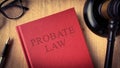 Probate law book on wooden table surrounded with gavel, glasses and pen. Law concept