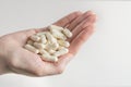 Probiotics. Preparation for restoration of intestinal microflora. Handful of white capsules with probiotic powder inside