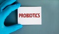 Probiotics symbol. Hand in blue glove with white card. Concept word `probiotics`. Medical and probiotics concept. Copy space,