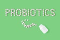 Probiotics word made of pills on green background. Flat lay, top view, free copy space.