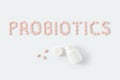 Probiotics word made of pink pills on white background. Flat lay, top view, free copy space