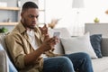 Discontented Black Guy Having Problem Using Mobile Phone At Home Royalty Free Stock Photo