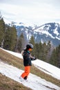 Problem of global warming and winter skiing. One Asian walking downhill with ski in hands. Climate change with disappearance of