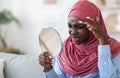 Problem Skin. Black Islamic Woman In Hijab Looking In Mirror At Home
