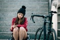 Problem teenager sitting consulting his phone, travels with bicycle