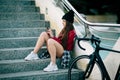 Problem teenager sitting consulting his phone, travels with bicycle